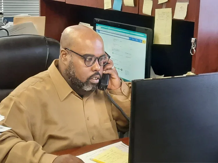 Clinton Roosevelt Dale, founder of the Blue Bear Foundation, working at his desk and speaking on the phone.